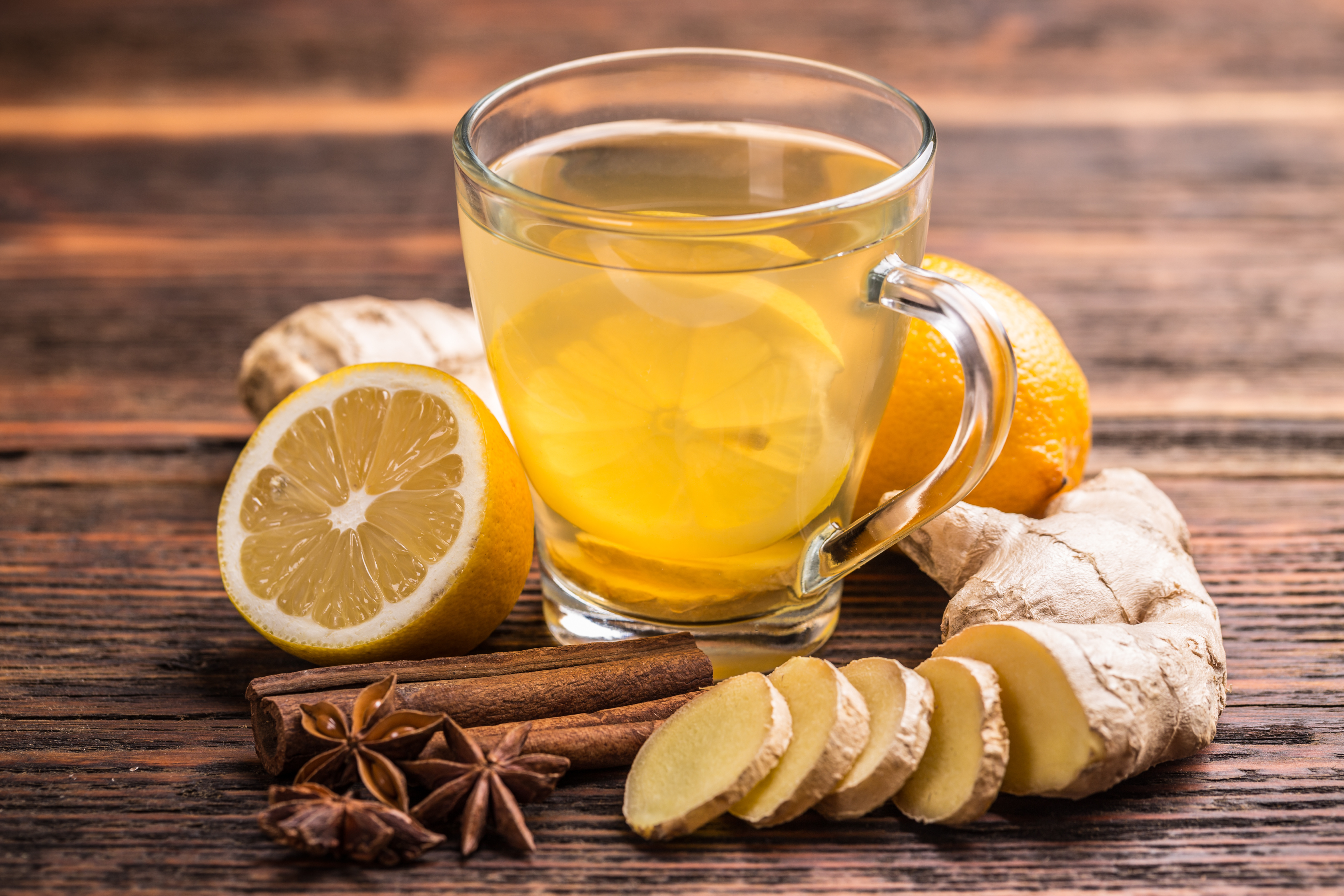 Cup of ginger tea with lemon on wooden table